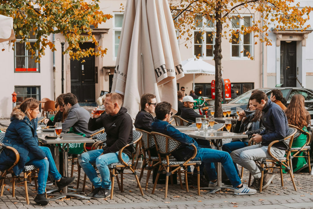 A group of people drinking beers outside on a terrace